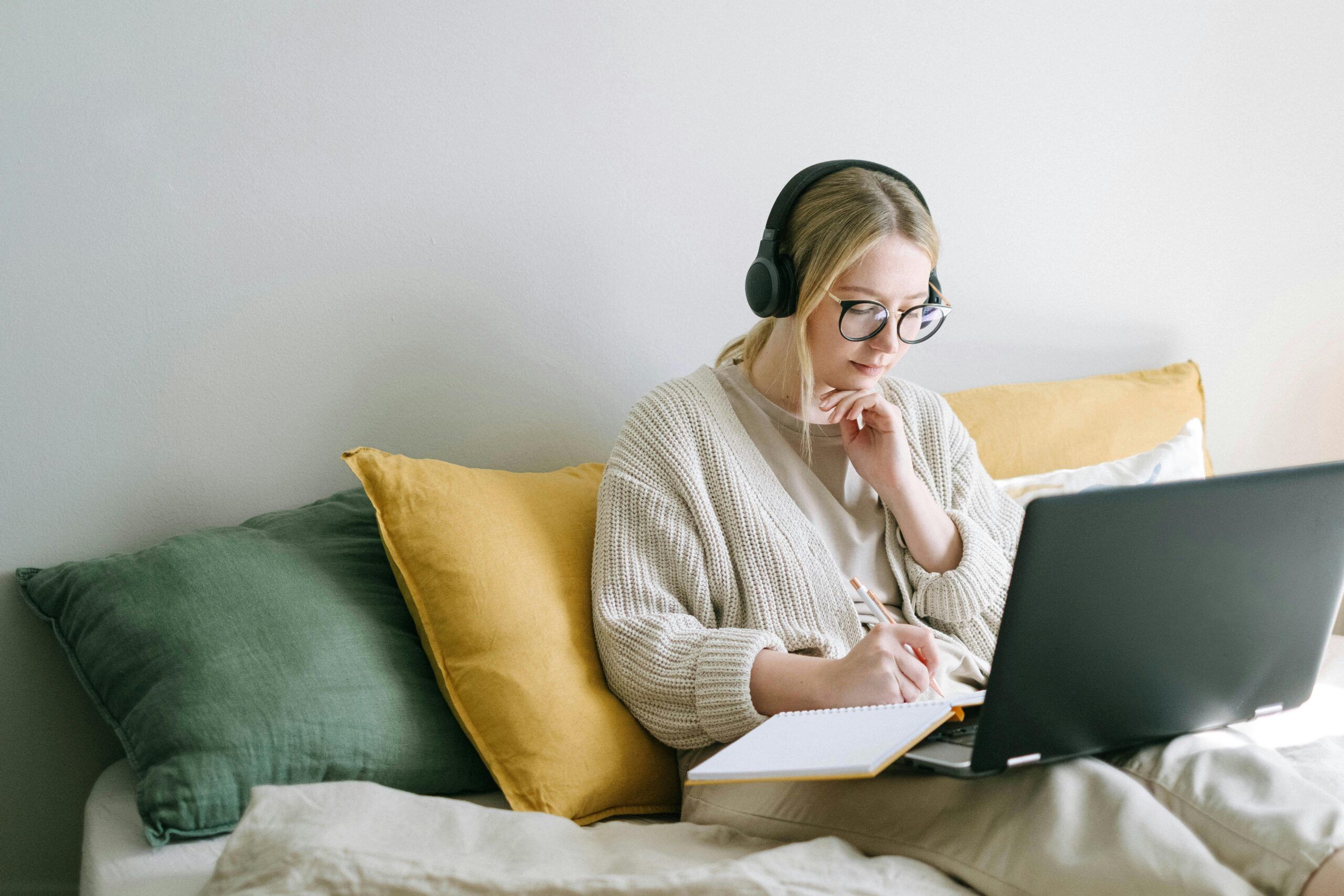 Vrouw die thuis ontspannen werkt achter haar laptop met een kopje koffie naast zich